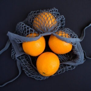 Mesh Shopping Gray Bag With Oranges On The Black Background.no P