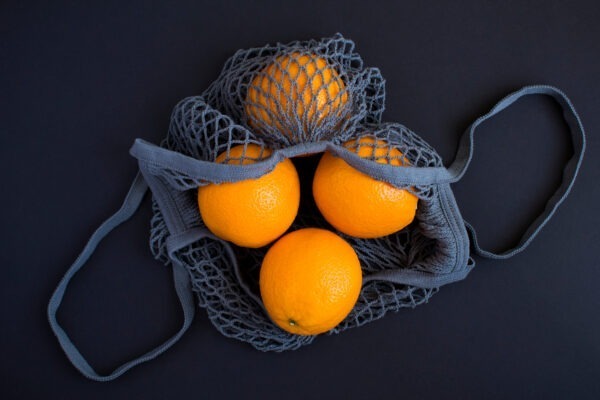 Mesh Shopping Gray Bag With Oranges On The Black Background.no P