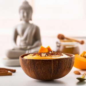 Firefly Pumpkin Spice Smoothie Bowl In A Smooth Coconut Bowl, Blurred Background On A White Counter