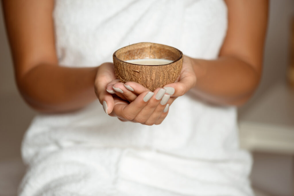 Close Up Of Girl Holding Coconut In Spa Salon.