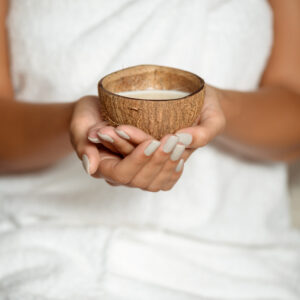 Close Up Of Girl Holding Coconut In Spa Salon.